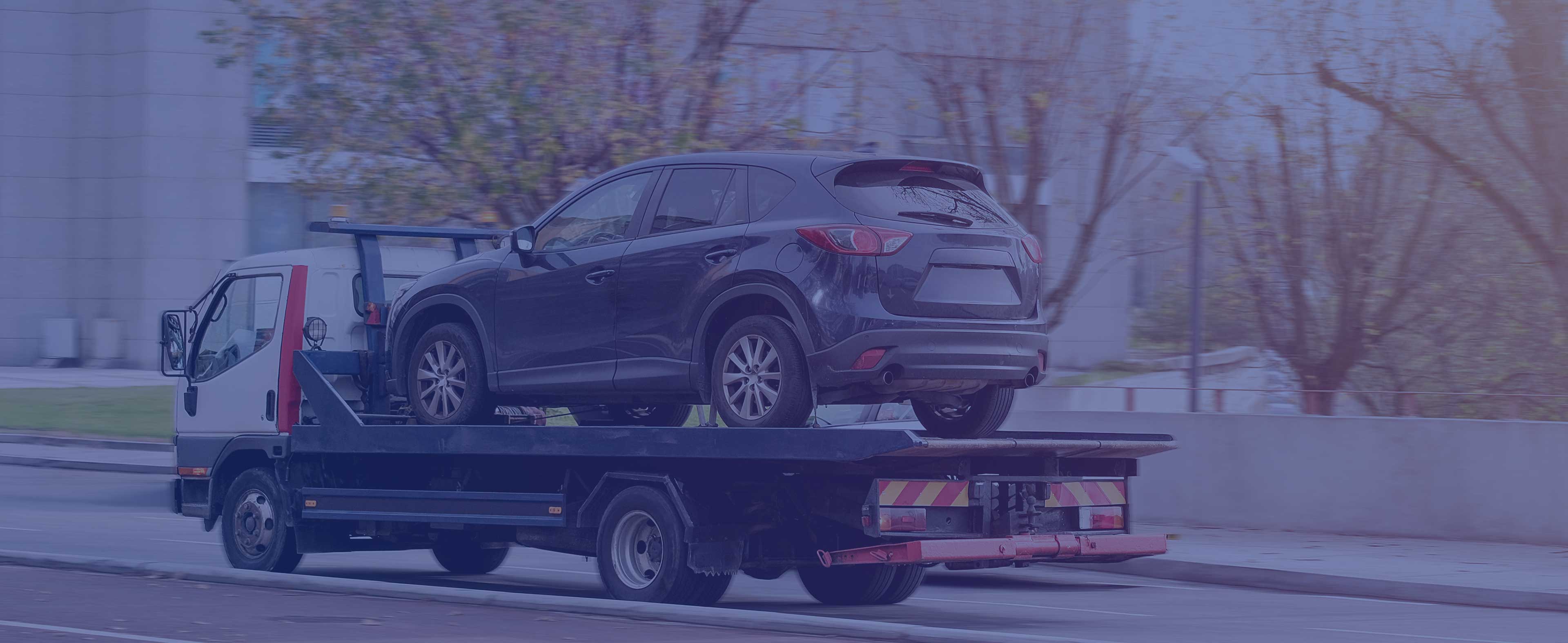 Grúa cargando camioneta en la ciudad